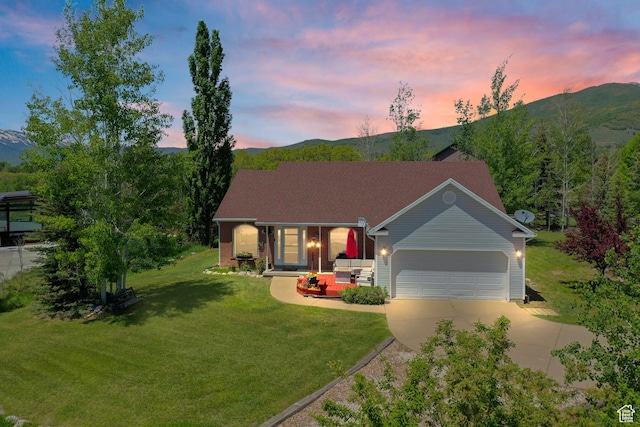 ranch-style home featuring a mountain view, driveway, and an attached garage