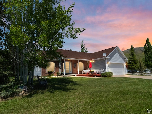 3677 N Willowbrook Ln, Eden, UT 84310 - ranch-style home with a garage, covered porch, a lawn, driveway, and brick siding