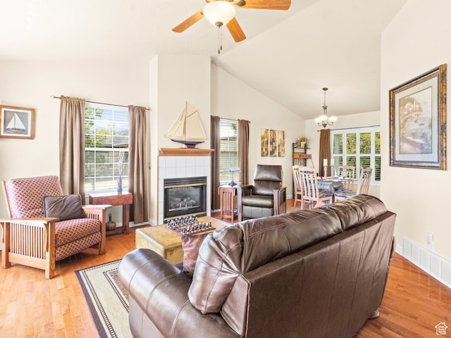3677 N Willowbrook Ln, Eden, UT 84310 - living room featuring light wood-style floors, visible vents, a tile fireplace, high vaulted ceiling, and ceiling fan with notable chandelier