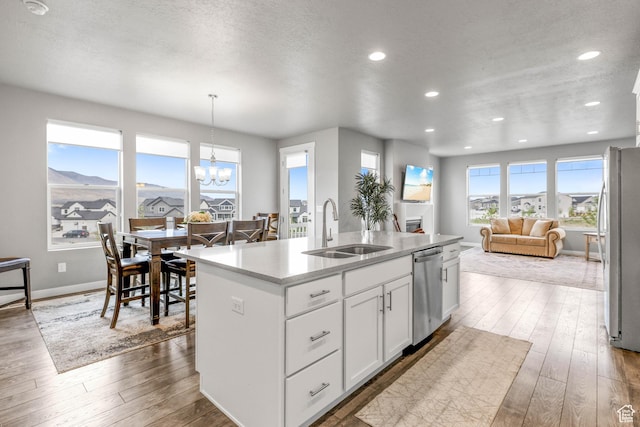 kitchen with hardwood / wood-style flooring, a sink, a chandelier, and stainless steel appliances