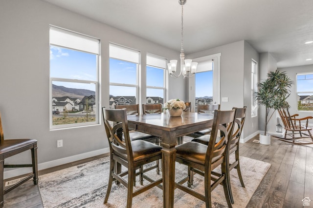 dining space featuring baseboards, recessed lighting, a notable chandelier, and wood-type flooring