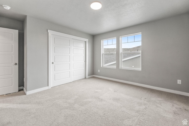 unfurnished bedroom featuring a closet, carpet, and baseboards