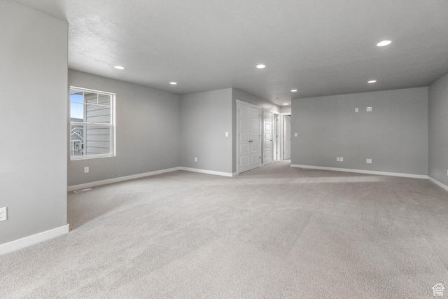 carpeted spare room featuring baseboards and recessed lighting