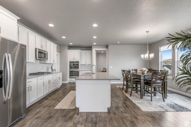 kitchen featuring a kitchen island with sink, stainless steel appliances, decorative backsplash, and recessed lighting