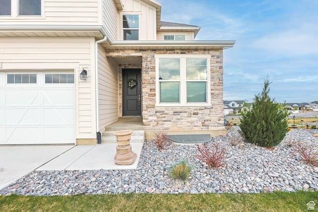 doorway to property with an attached garage and stone siding
