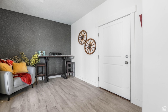 foyer entrance with wood finished floors and baseboards