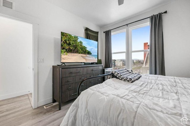 bedroom with light wood-style flooring, baseboards, and a ceiling fan