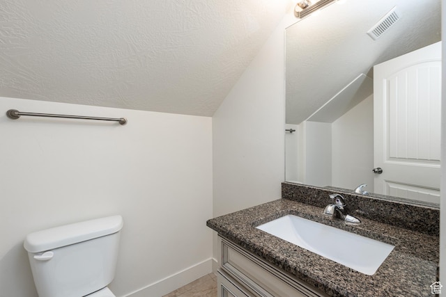 bathroom with vaulted ceiling, toilet, vanity, baseboards, and visible vents