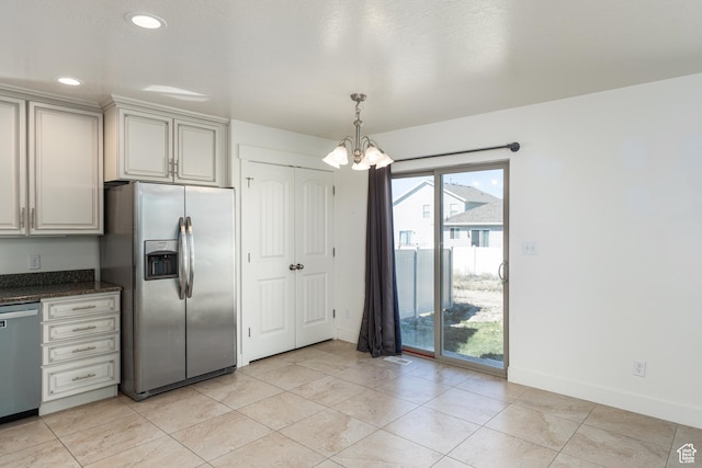 kitchen with an inviting chandelier, stainless steel appliances, dark stone countertops, visible vents, and baseboards
