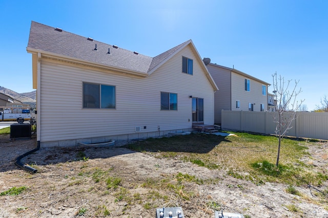 rear view of property with roof with shingles, central AC, entry steps, and fence