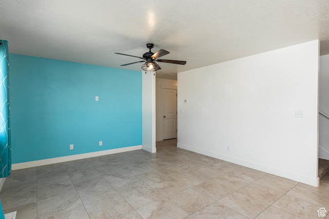 unfurnished room featuring baseboards, ceiling fan, and a textured ceiling