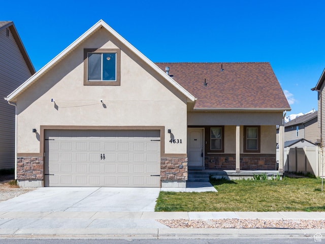 view of front facade with a front yard, covered porch, driveway, stone siding, and stucco siding