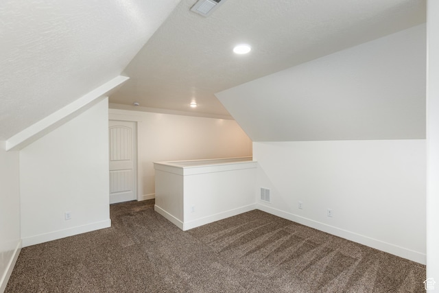 additional living space featuring recessed lighting, vaulted ceiling, baseboards, visible vents, and dark carpet