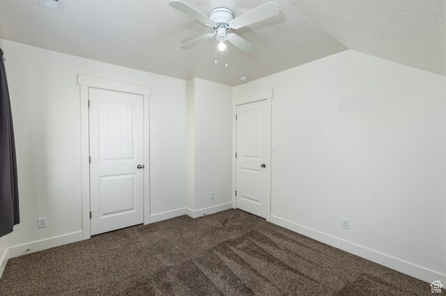 unfurnished bedroom with carpet, baseboards, vaulted ceiling, and a textured ceiling