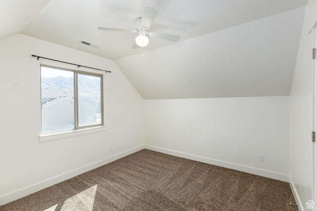 bonus room with dark colored carpet, visible vents, baseboards, vaulted ceiling, and a ceiling fan