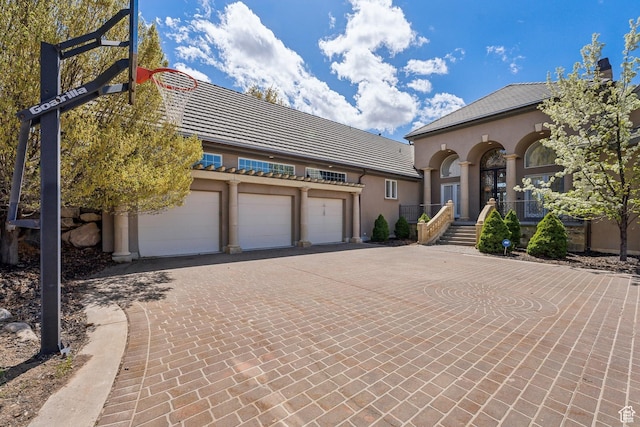 1714 Ridge Point Dr, Bountiful, UT 84010 - mediterranean / spanish-style house featuring stucco siding, decorative driveway, a tiled roof, and a garage
