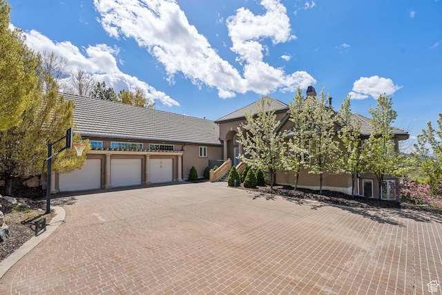 1714 Ridge Point Dr, Bountiful, UT 84010 - view of front of property with a garage, stucco siding, a tile roof, and decorative driveway