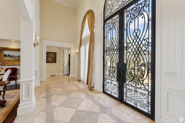 1714 Ridge Point Dr, Bountiful, UT 84010 - entrance foyer with a high ceiling, crown molding, a decorative wall, ornate columns, and french doors