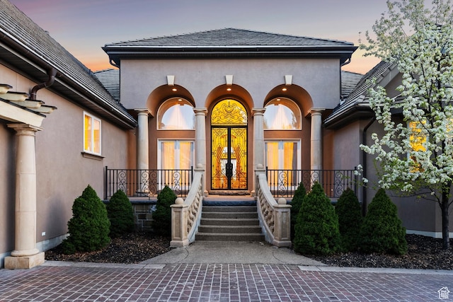 1714 Ridge Point Dr, Bountiful, UT 84010 - exterior entry at dusk featuring stucco siding and covered porch