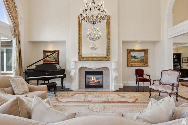 1714 Ridge Point Dr, Bountiful, UT 84010 - sitting room featuring a high end fireplace, baseboards, wood finished floors, a notable chandelier, and a high ceiling