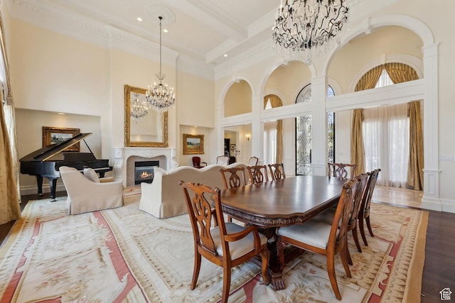 1714 Ridge Point Dr, Bountiful, UT 84010 - dining space with crown molding, an inviting chandelier, a glass covered fireplace, wood finished floors, and a high ceiling
