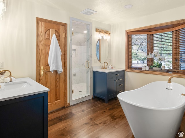 4120 S Beus Dr E, Ogden, UT 84403 - bathroom featuring a sink, a marble finish shower, two vanities, wood finished floors, and a freestanding bath