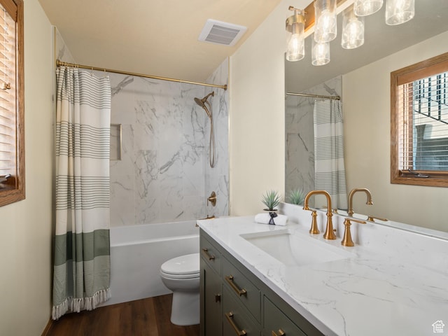 4120 S Beus Dr E, Ogden, UT 84403 - bathroom with wood finished floors, shower / bath combo with shower curtain, toilet, vanity, and visible vents