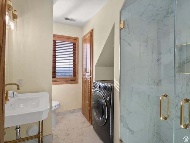 4120 S Beus Dr E, Ogden, UT 84403 - full bathroom featuring washer / dryer, toilet, a marble finish shower, visible vents, and baseboards