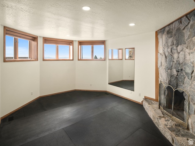 4120 S Beus Dr E, Ogden, UT 84403 - unfurnished living room with baseboards, recessed lighting, a textured ceiling, and a stone fireplace