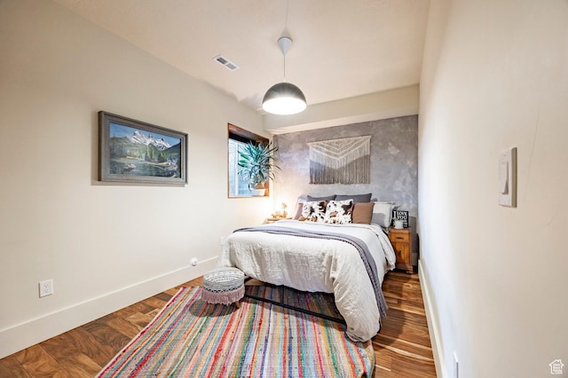 bedroom featuring visible vents, baseboards, and wood finished floors