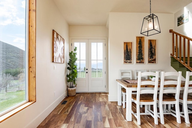 dining space featuring a healthy amount of sunlight, baseboards, wood finished floors, and visible vents