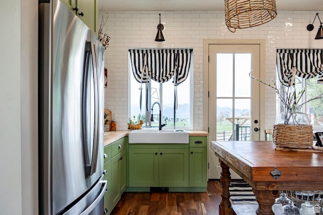 kitchen featuring a sink, a wealth of natural light, green cabinets, and freestanding refrigerator
