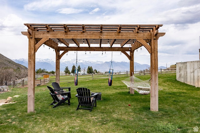view of home's community featuring fence, a mountain view, a yard, and a pergola