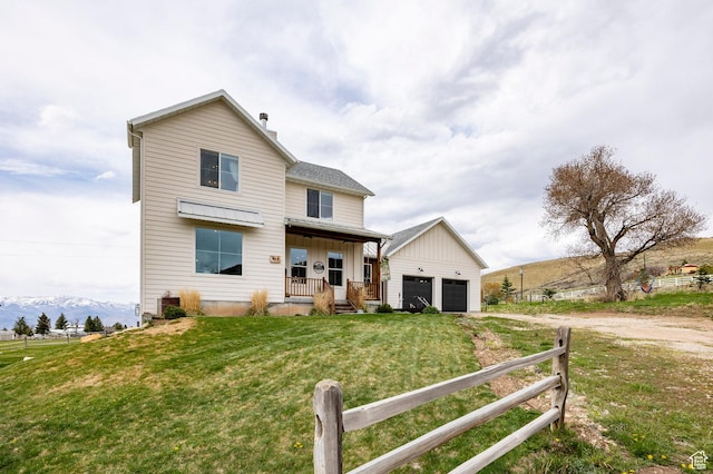 view of front of home featuring fence, covered porch, a front yard, board and batten siding, and driveway