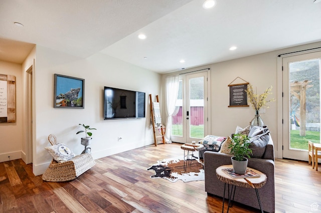 living area with recessed lighting, baseboards, and wood finished floors