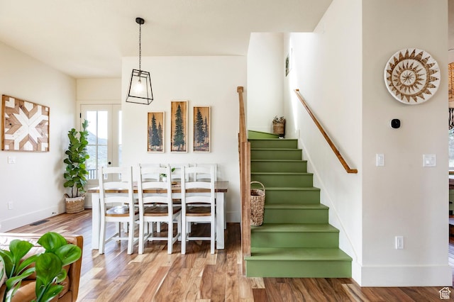 interior space with stairway, baseboards, wood finished floors, and visible vents