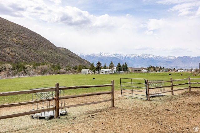 view of yard featuring a mountain view, a rural view, and fence