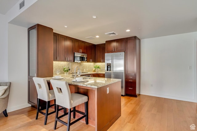 45 W S Temple St Unit 701, Salt Lake City, UT 84101 - kitchen with visible vents, stainless steel appliances, light wood-type flooring, and a peninsula