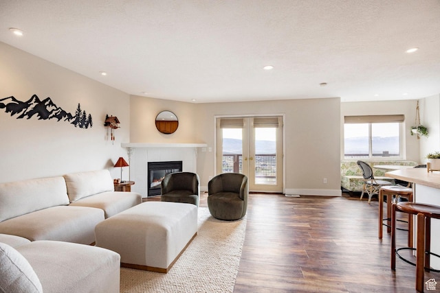 living area with dark wood-style flooring, plenty of natural light, and recessed lighting