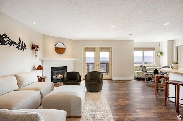 living room with recessed lighting, a tile fireplace, dark wood-style flooring, and baseboards