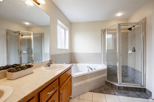 bathroom with tile patterned floors, a garden tub, a stall shower, and a sink