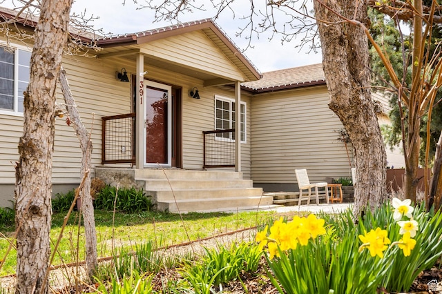 property entrance featuring a shingled roof