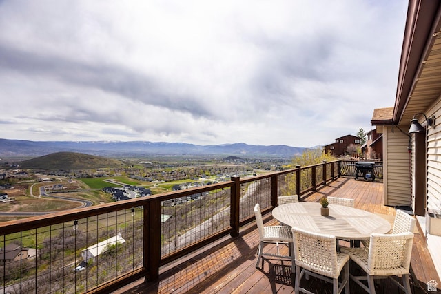 wooden terrace with a mountain view and outdoor dining area