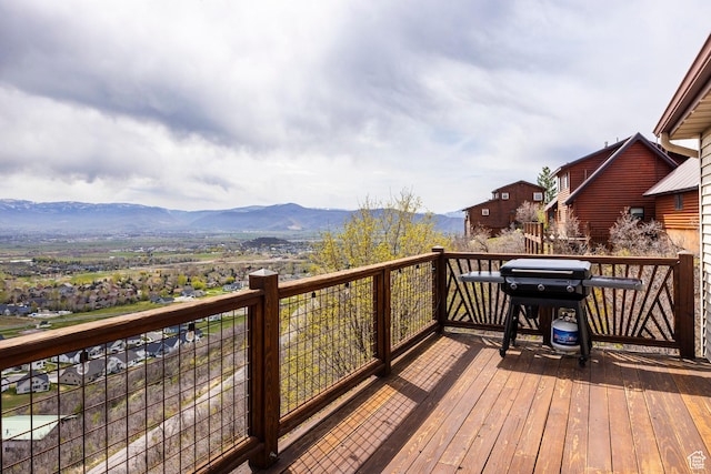 wooden deck with a mountain view and grilling area