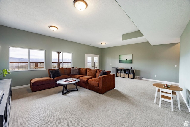 living area featuring visible vents, light carpet, and baseboards