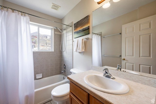bathroom featuring toilet, visible vents, shower / bath combo with shower curtain, and vanity