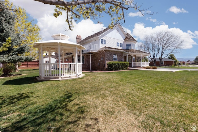 889 Upland Dr, Richfield, UT 84701 - exterior space with a gazebo, covered porch, fence, brick siding, and a front lawn