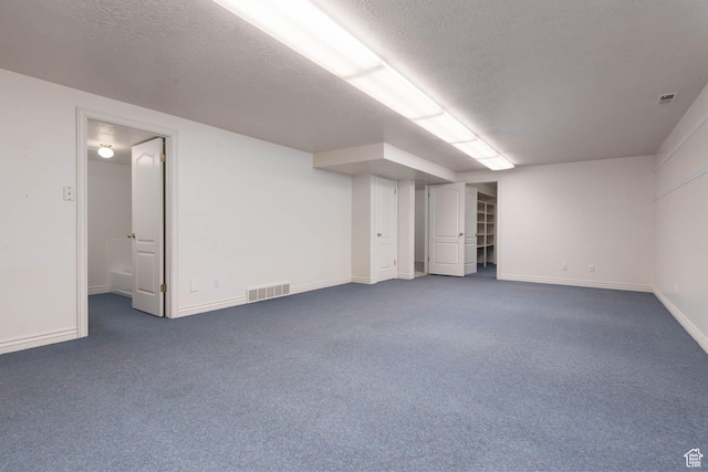 889 Upland Dr, Richfield, UT 84701 - finished below grade area with dark carpet, a textured ceiling, and visible vents