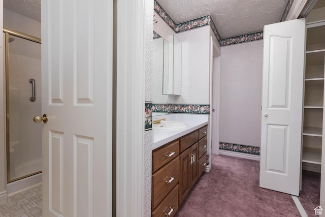 889 Upland Dr, Richfield, UT 84701 - bathroom with a spacious closet, a shower stall, a textured ceiling, and vanity