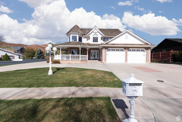 view of front of property featuring driveway, covered porch, an attached garage, brick siding, and a front lawn